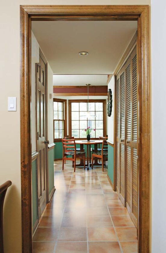 AFTER: The view from the front entry foyer to the backyard was enhanced with fresh paint and a darker floor tile, which lends visual weight. Lowering the hall ceiling to 7 feet created a transition area between the foyer and kitchen.